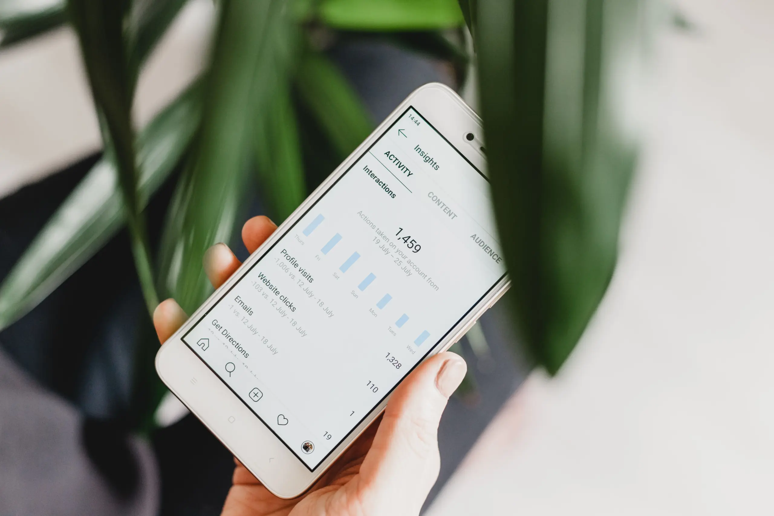 A person holding a smartphone with content Insights opened on the screen